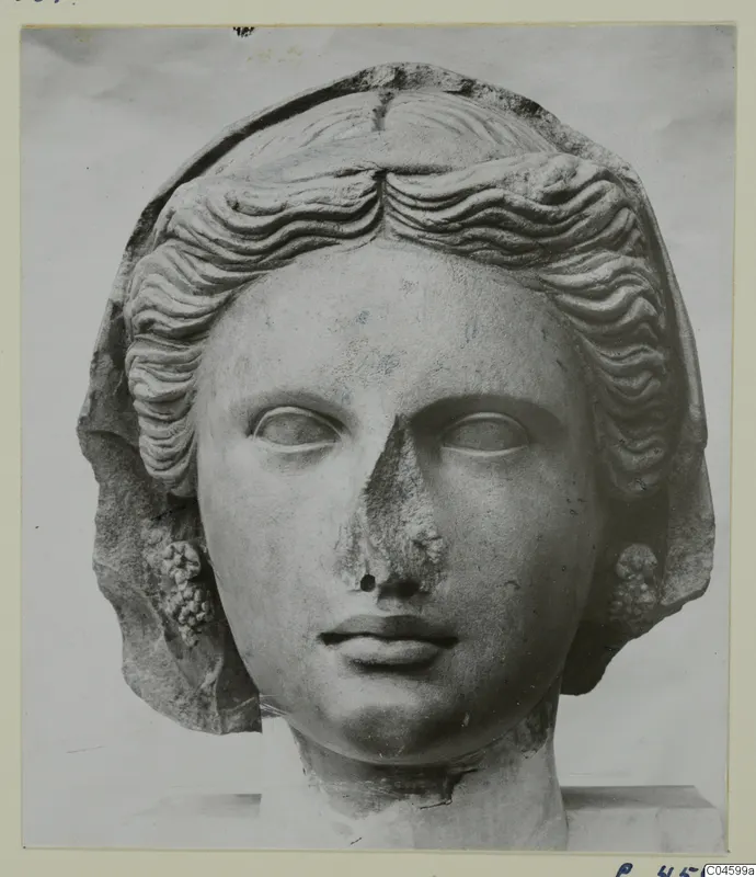 Marble head of a young woman with wavy hair swept back, the nose broken away