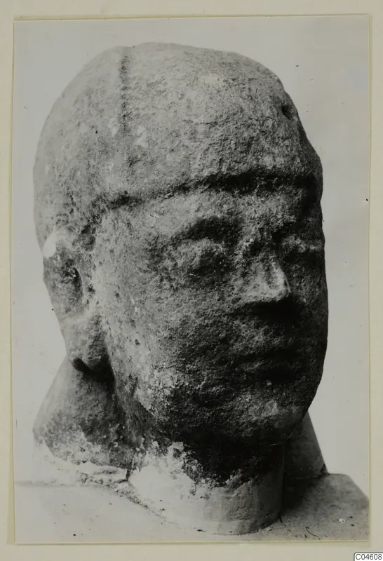 Limestone head with a broad face and weathered surface, photographed in three-quarter view