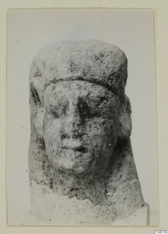 Limestone sculpture of a head with a flat cap and rounded ears, Proto-Cypriote, shown frontally