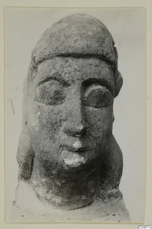 Close-up of a limestone head sculpture with a flat-topped headdress and large almond-shaped eyes