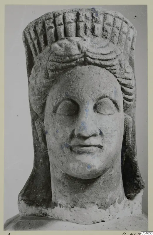 Stone statue head with a tall grooved headdress, from Arsos