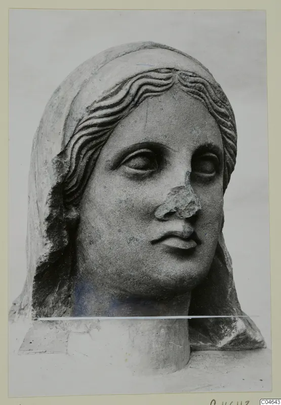 Stone statue head from Arsos, wearing a veil, with wavy hair and a broken nose