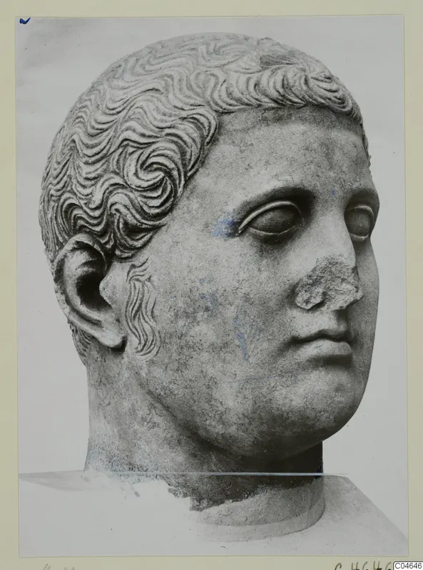 Carved stone head from Arsos, shown in three-quarter view with curled hair and a broken nose.
