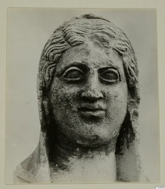 Carved stone head and upper shoulders of a statue from Arsos, shown frontally with wavy hair and large eyes