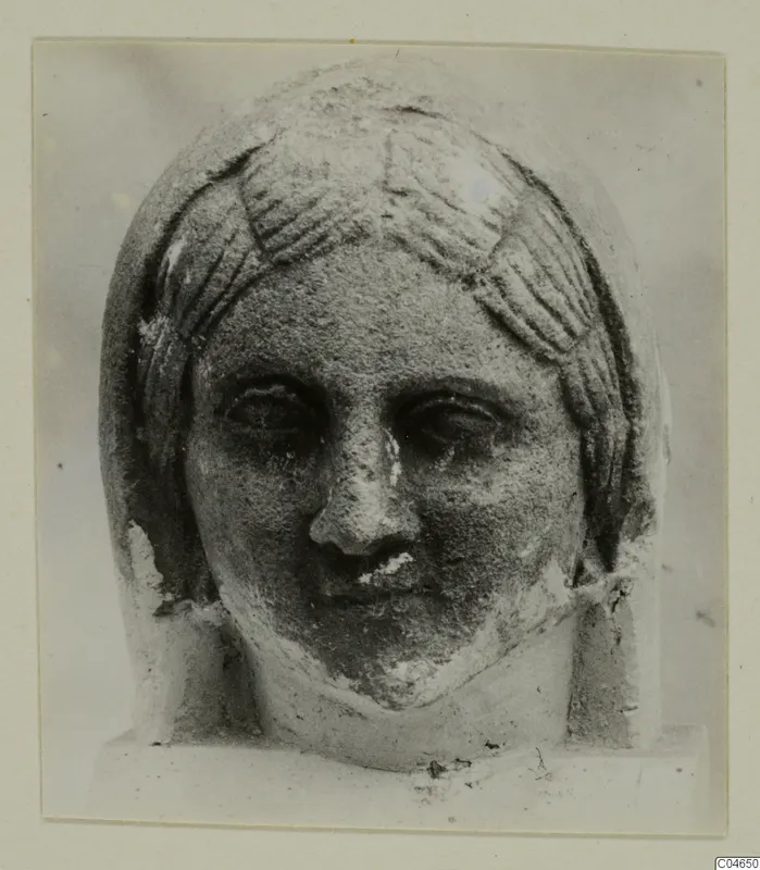 Stone statue head from Arsos, face and hair in front view, nose and lips worn.