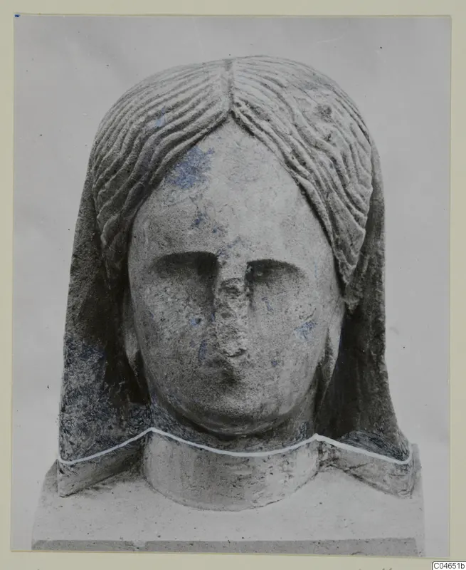 Stone head sculpture from Arsos, front view, with wavy hair parted at the centre and a broken nose