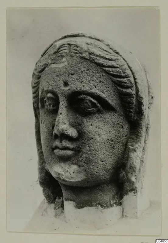 Stone statue head from Arsos, shown close up with wavy hair bands and a broken neck.