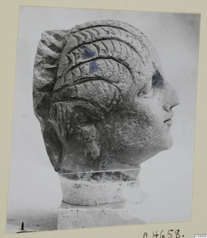 Stone head of a statue from Arsos, shown in profile facing right, with ridged hair and a short neck on a square base