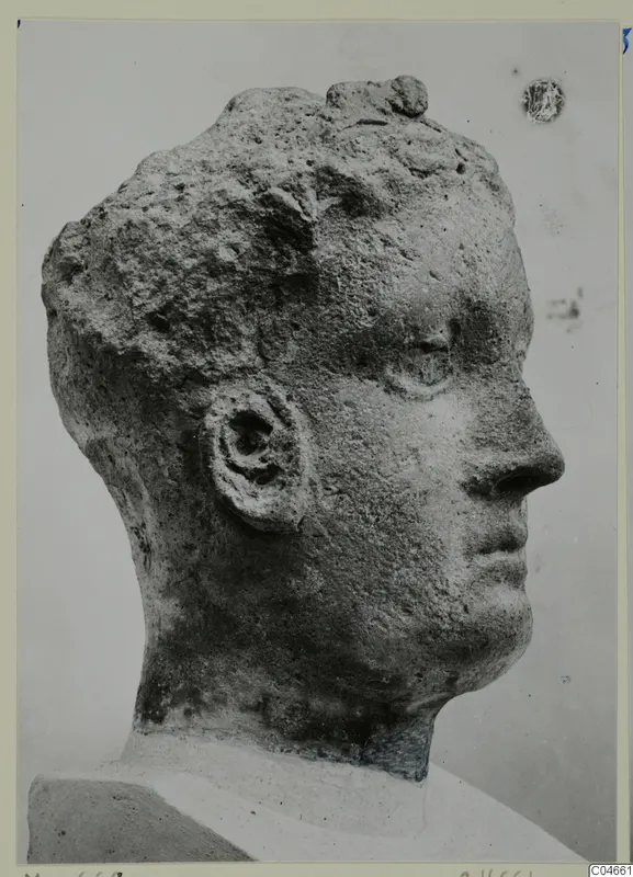 Profile of a carved stone head from Mersinaki, with a pitted surface and a small section of shoulder below
