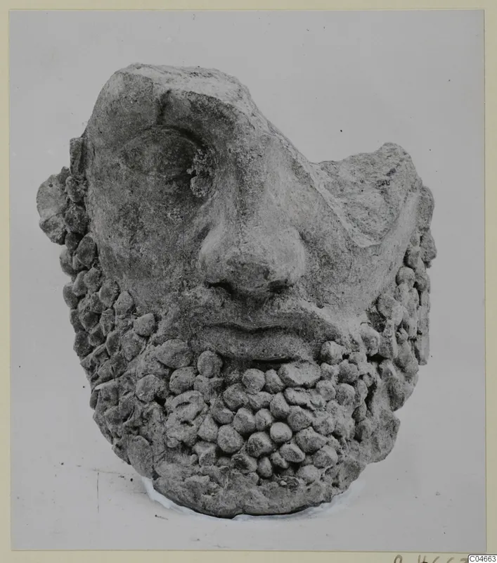 Terracotta head from Mersinaki with a broad nose and a beard of rounded knobs, shown from the front.