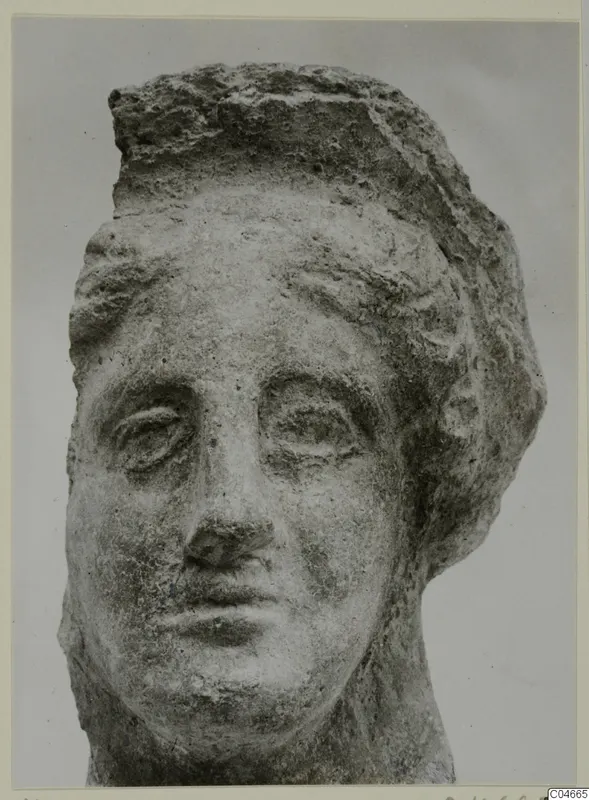 Head of a stone statue from Mersinaki, with a weathered face and a thick mass of hair.