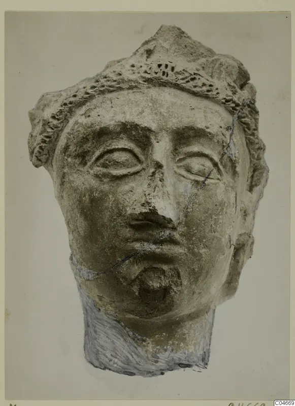Head of a figure from Mersinaki with a ridged headband, almond-shaped eyes and a chipped nose, seen from the front.