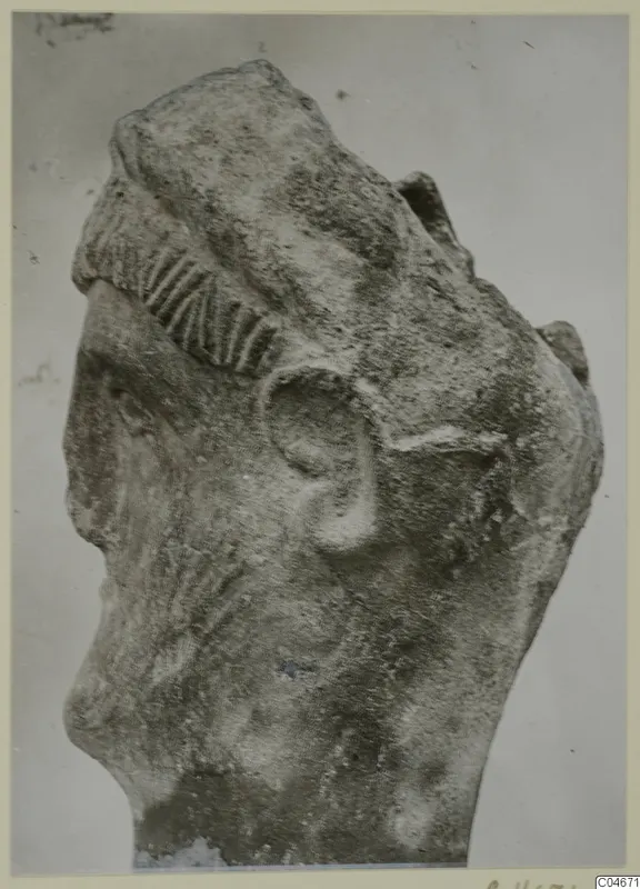 Limestone sculpture head from Mersinaki, with a ridged band over the hair and the ear visible in profile.