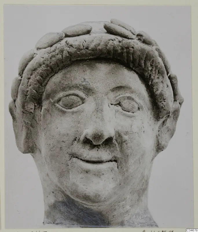Terracotta head of a figure with a band of rounded curls around the forehead, from Mersinaki