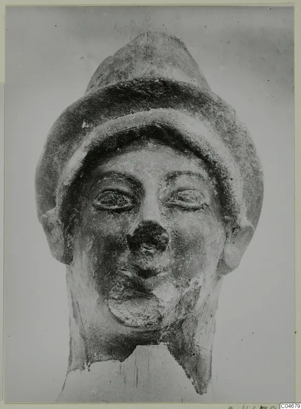 Head from Mersinaki with a tall, banded cap, large eyes and a damaged nose, neck broken off at the base