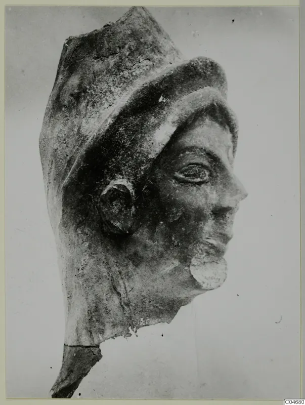 Head of a sculpture in profile, with a tall headdress and a curled beard, from Mersinaki