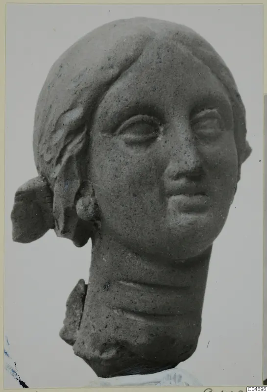 Female head fragment in terracotta from Soli, hair drawn back, neck broken off