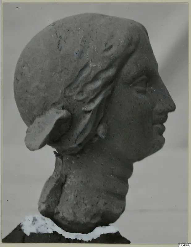 Terracotta head in right profile, with waved hair drawn back from the brow and a large ear