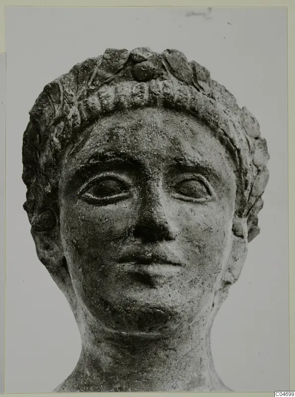 Terracotta Cypro-Greek II: sculpted head wearing a leafy wreath, shown from the front.