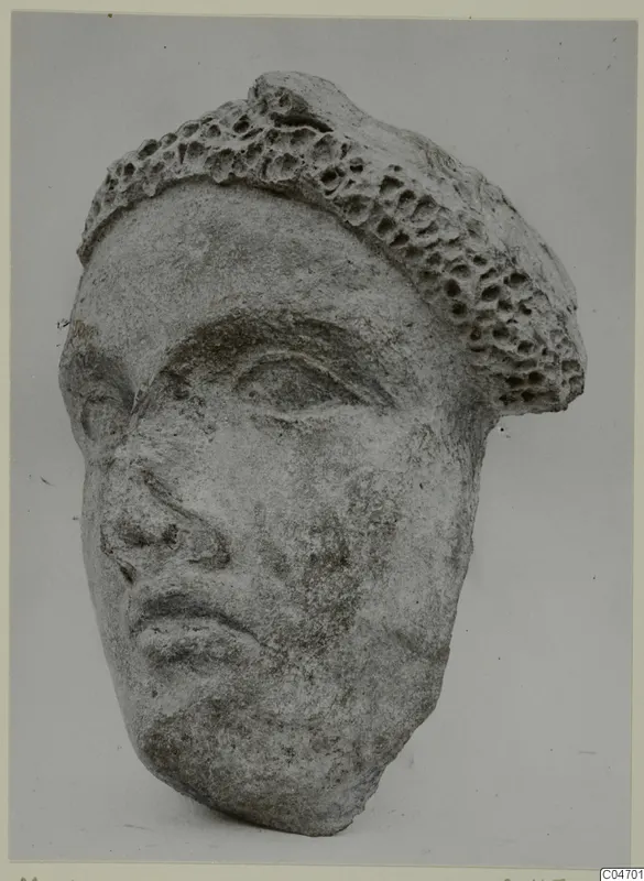 Stone head from Mersinaki with heavy brows, almond eyes and a pitted, honeycomb-textured top
