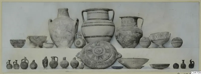 Pottery vessels from Amathus Tomb 5, arranged in two rows against a pale backdrop.