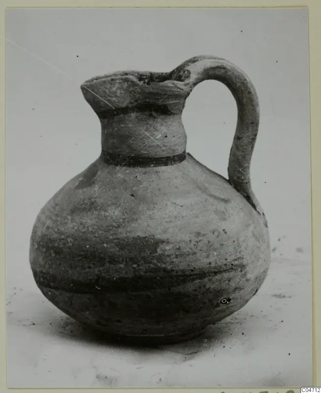 Pottery Bichrome V jug with a single loop handle and dark painted bands on the neck and body