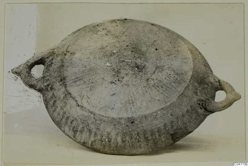 Flattened pottery vessel with two loop handles, from Amathus, photographed on a light background