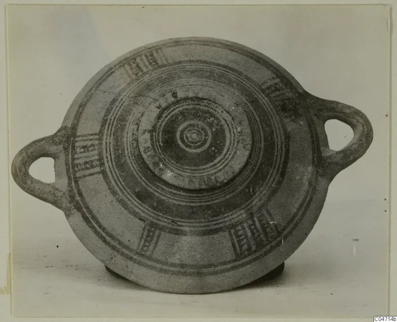Pottery Bichrome III vessel with two loop handles, seen from above, with dark painted concentric rings and hatched panels
