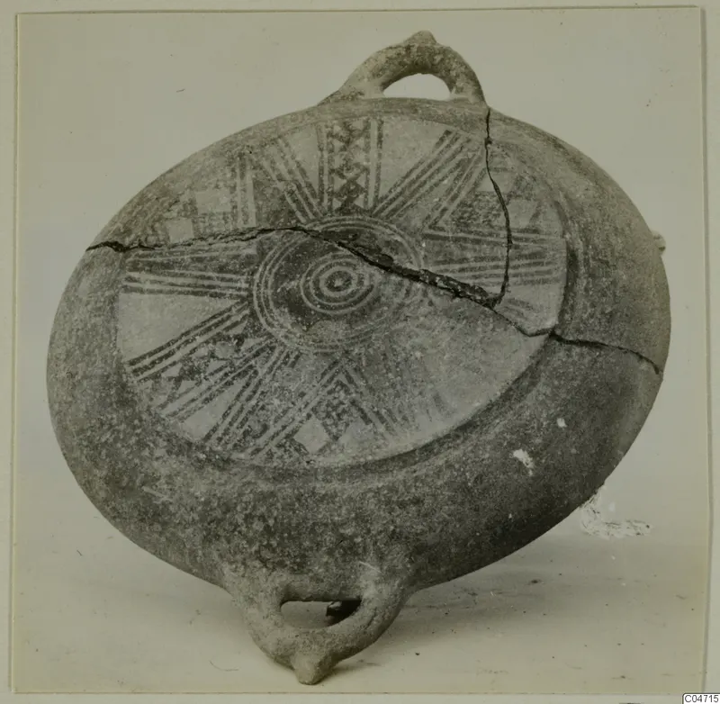 Flattened round pottery vessel with a loop handle and painted radiating bands, from Amathus