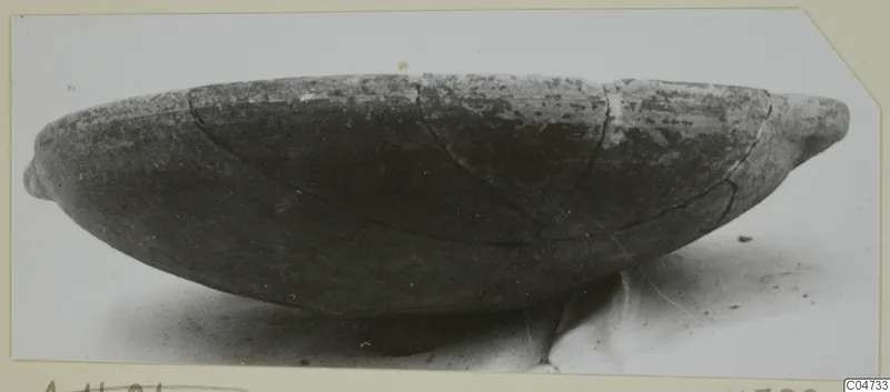 Pottery Red Slip bowl, shallow and wide, photographed in side view with small projections at each end