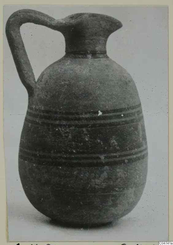 Pottery Bichrome III jug from Amathus, with a single loop handle and dark horizontal bands on the body