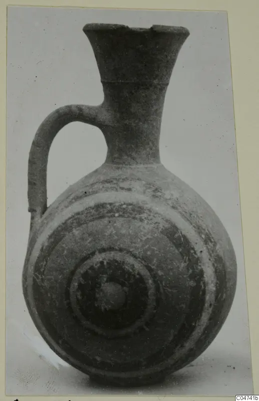 Pottery jug with a flaring neck, a single loop handle and concentric bands on the rounded body