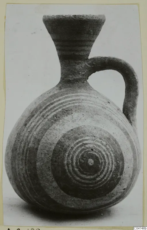 Pottery White Painted IV jug with a flaring neck, strap handle and concentric circles painted on the body