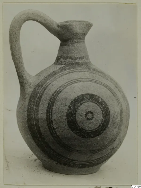 Round-bodied jug with a tall loop handle and concentric circles painted in dark bands on its body.