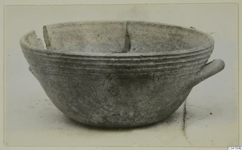 Pottery bowl with ridged rim grooves and a short horizontal handle on the right, broken at the rim