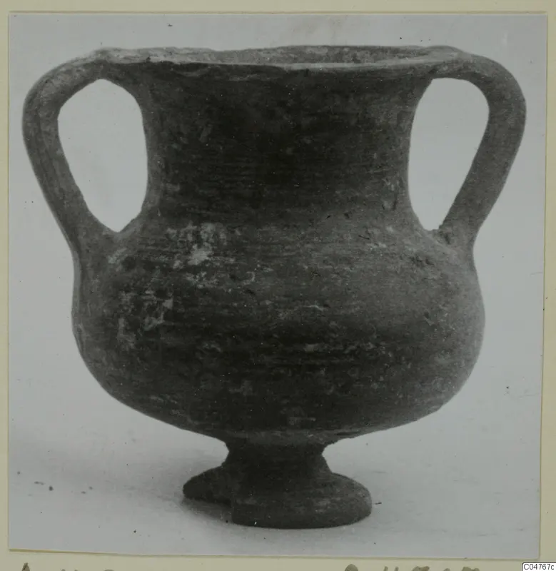 Two-handled vessel with a wide rounded body and short ring foot, seen from the side.