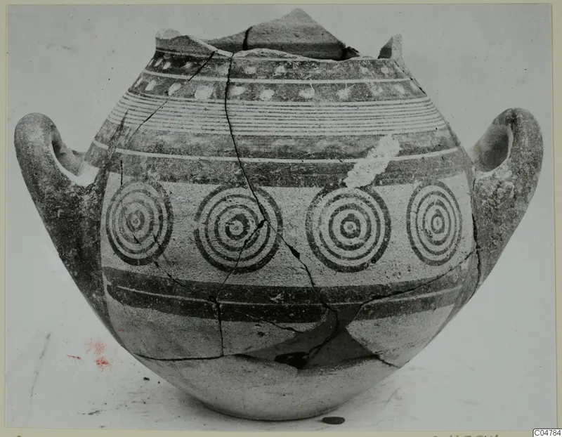 Two-handled jar painted with concentric circles and horizontal bands, shown against a plain background