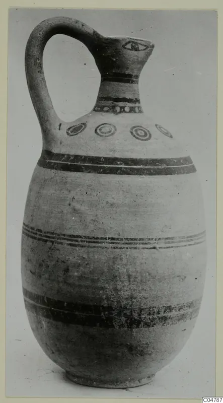 Painted pottery jug with a loop handle, dark bands and a row of concentric circles on the shoulder
