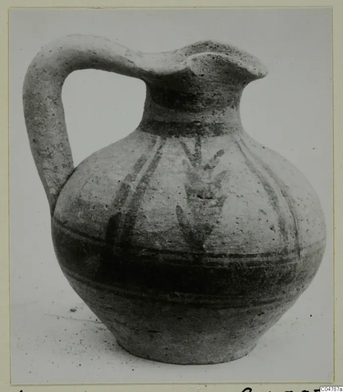 Pottery jug from Amathus with a strap handle, pinched spout and dark painted bands and strokes on the body