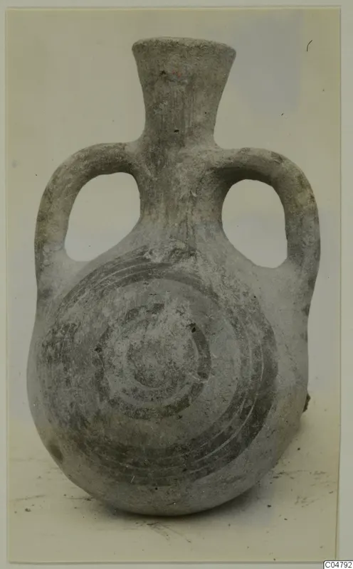 Grey-surfaced two-handled jug with a spiral pattern painted on its body, photographed against a pale backdrop.