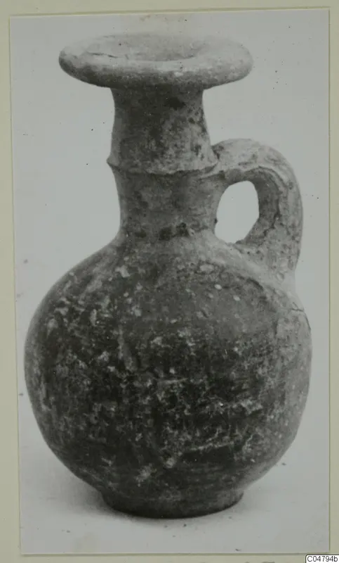 Grey Polished Ware jug with a flaring rim and a single loop handle