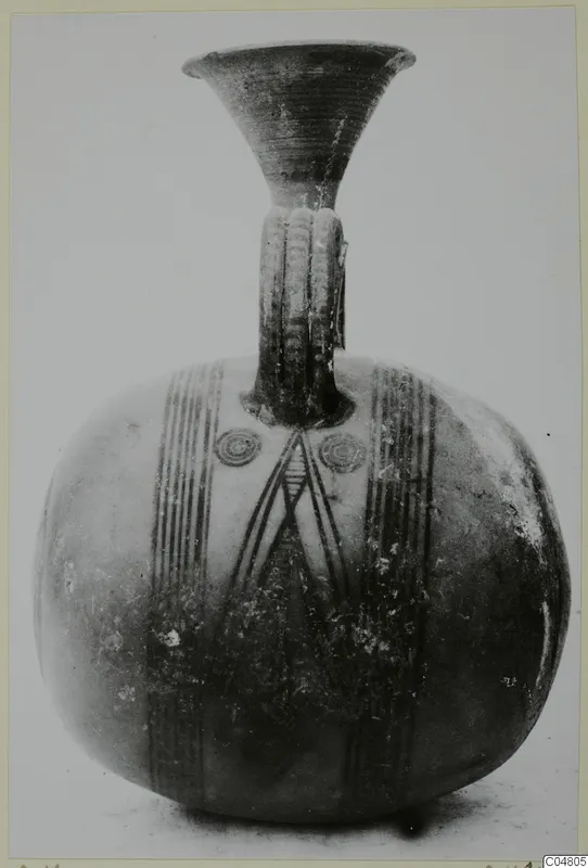Painted pottery vessel with a flaring neck and ribbed strap handle, with vertical bands and concentric circles in dark paint