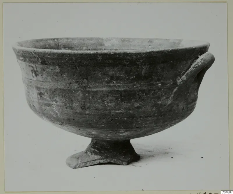 Pottery White Painted III bowl on a low pedestal foot, with one handle on the right