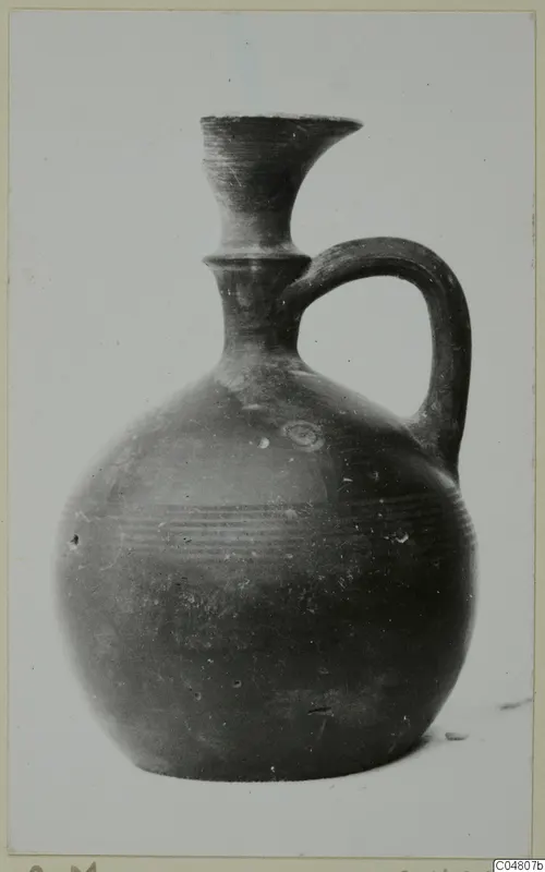 Pottery jug with a flaring neck, single loop handle and horizontal ridged bands on the body