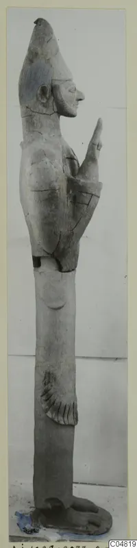 Terracotta Proto-Cypriote II statue, a tall standing figure in profile with a pointed headdress and one arm raised