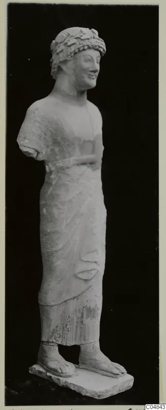 Limestone statue of a standing figure from Kition, wearing a leafy wreath and a long draped garment