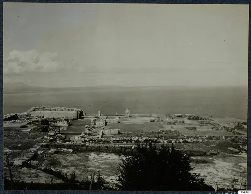 Ruins of the palace at Vouni, with low wall foundations in the foreground and the sea and distant hills beyond.