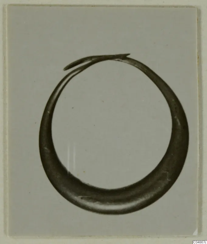Hoop-shaped metal earring from Enkomi, thick at the base and tapering to overlapping ends at the top