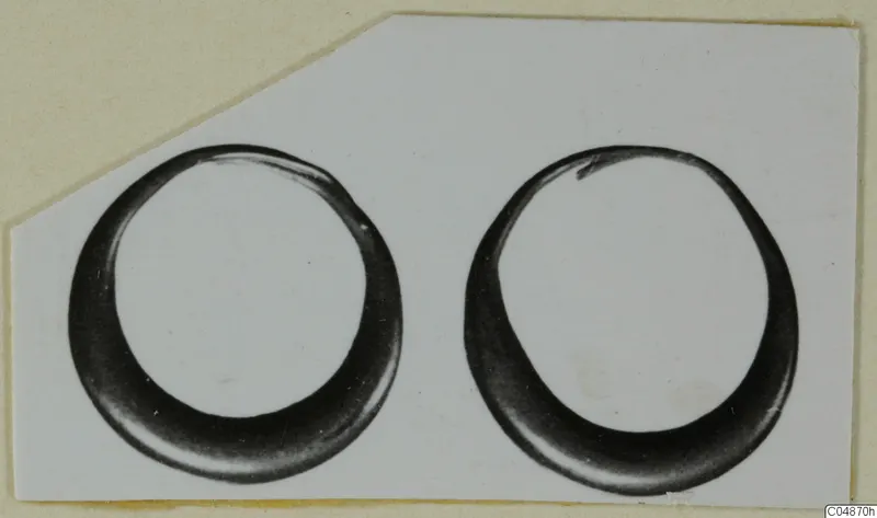 Two gold rings from Enkomi, photographed side by side on a light card mount