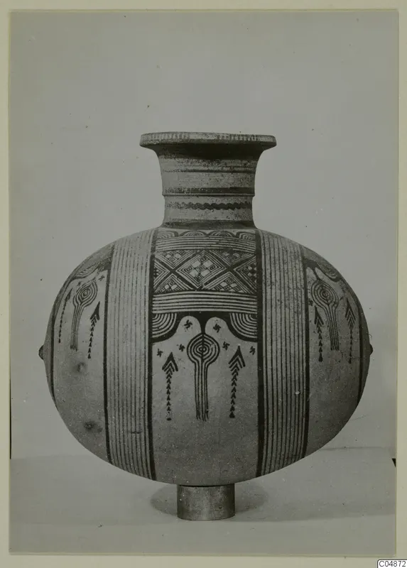 Pottery Bichrome IV jug with a flaring neck, painted vertical bands and a central motif, shown on a short stand.